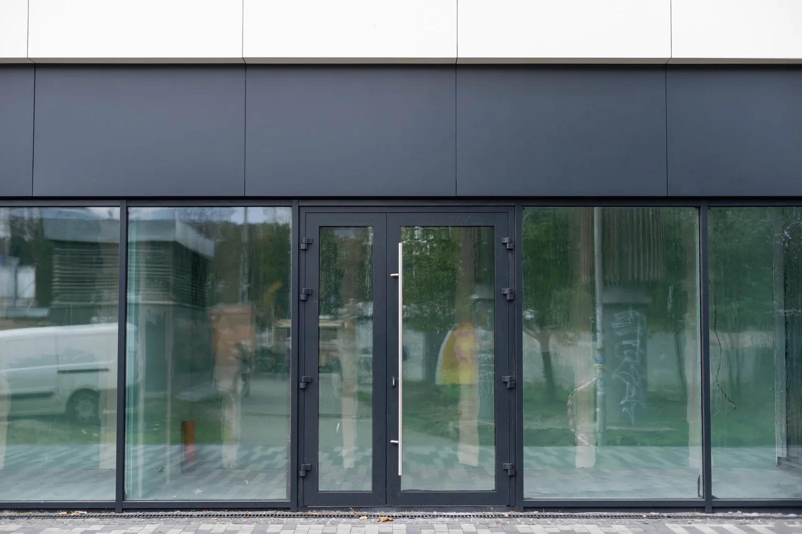 Clean commercial storefront glass and entry doors along a business sidewalk