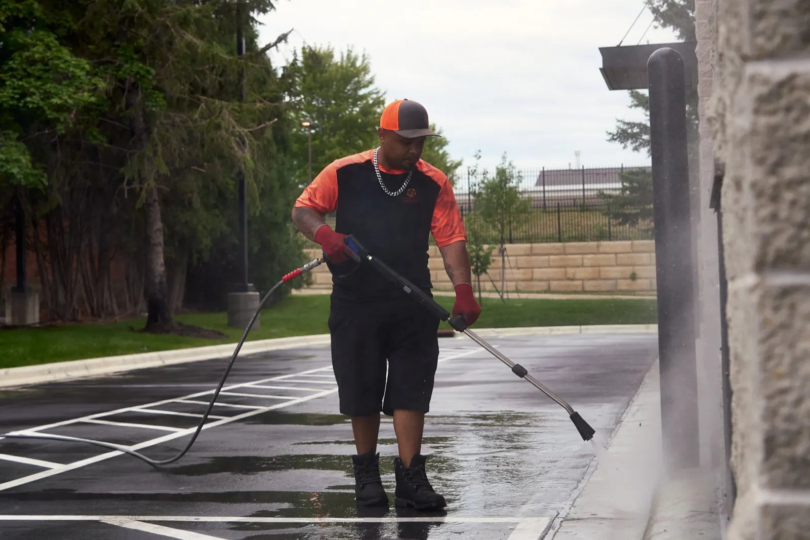 Commercial walkway being pressure washed beside a stone building