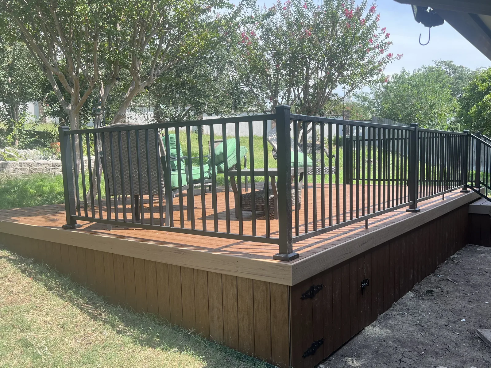 Composite deck with a black railing and skirting with an access door