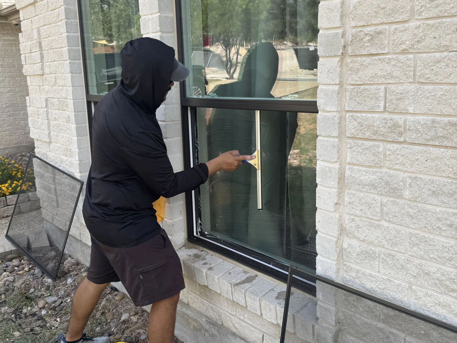 Squeegee pulling soapy water off an arched window during a window cleaning job